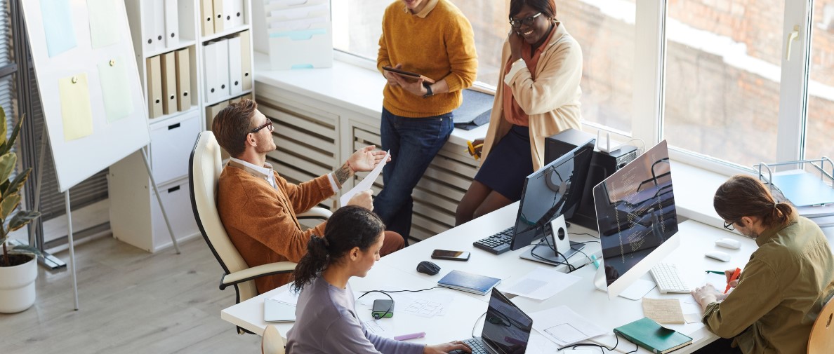 A Group of Diverse Adults in an IT Office Setting, discussing projects and completing tasks