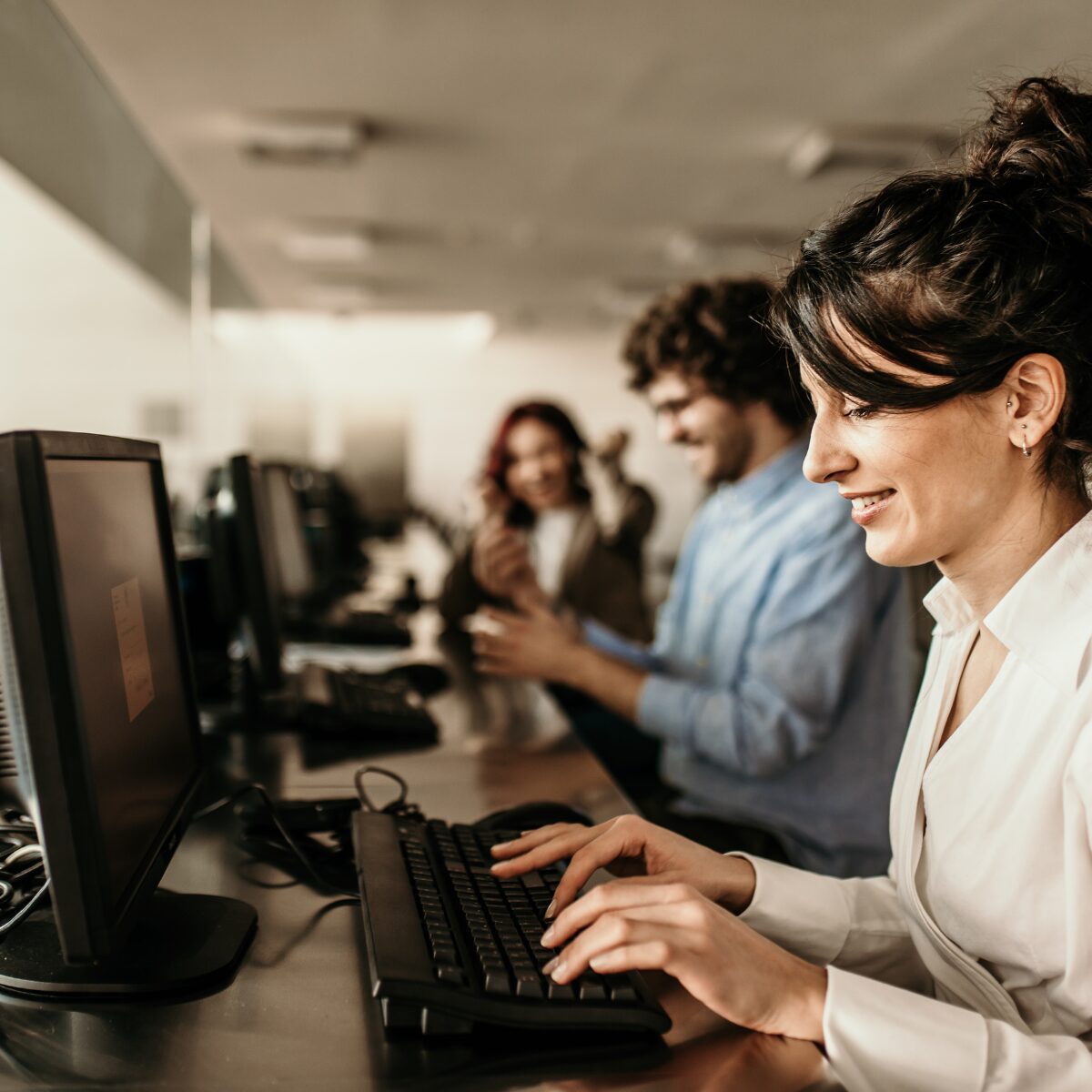 IT engineer providing technical support on a computer in an office environment